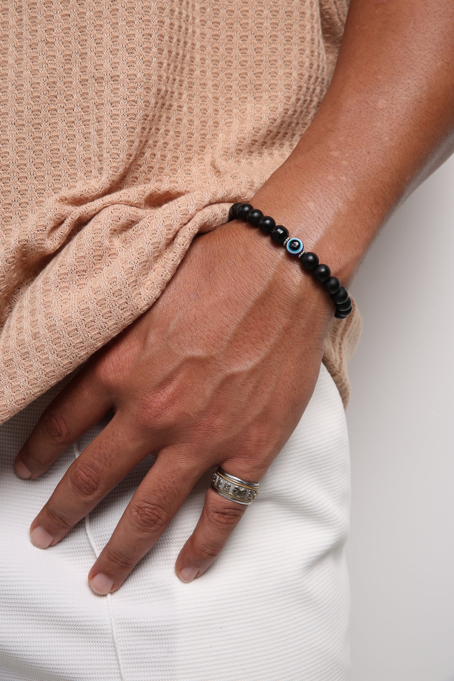 Matte glass beaded bracelet featuring a blue evil eye charm